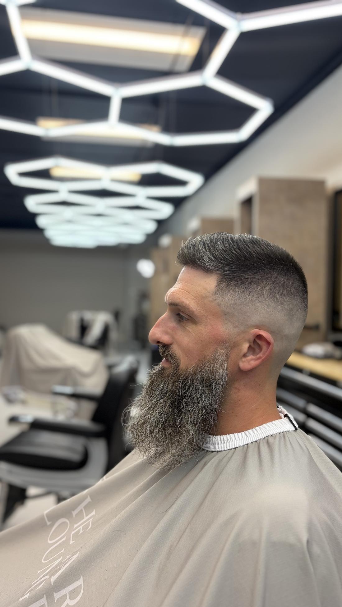 High skin fade with a long gray beard, cut at The Barber Lounge in Carthage, MO
